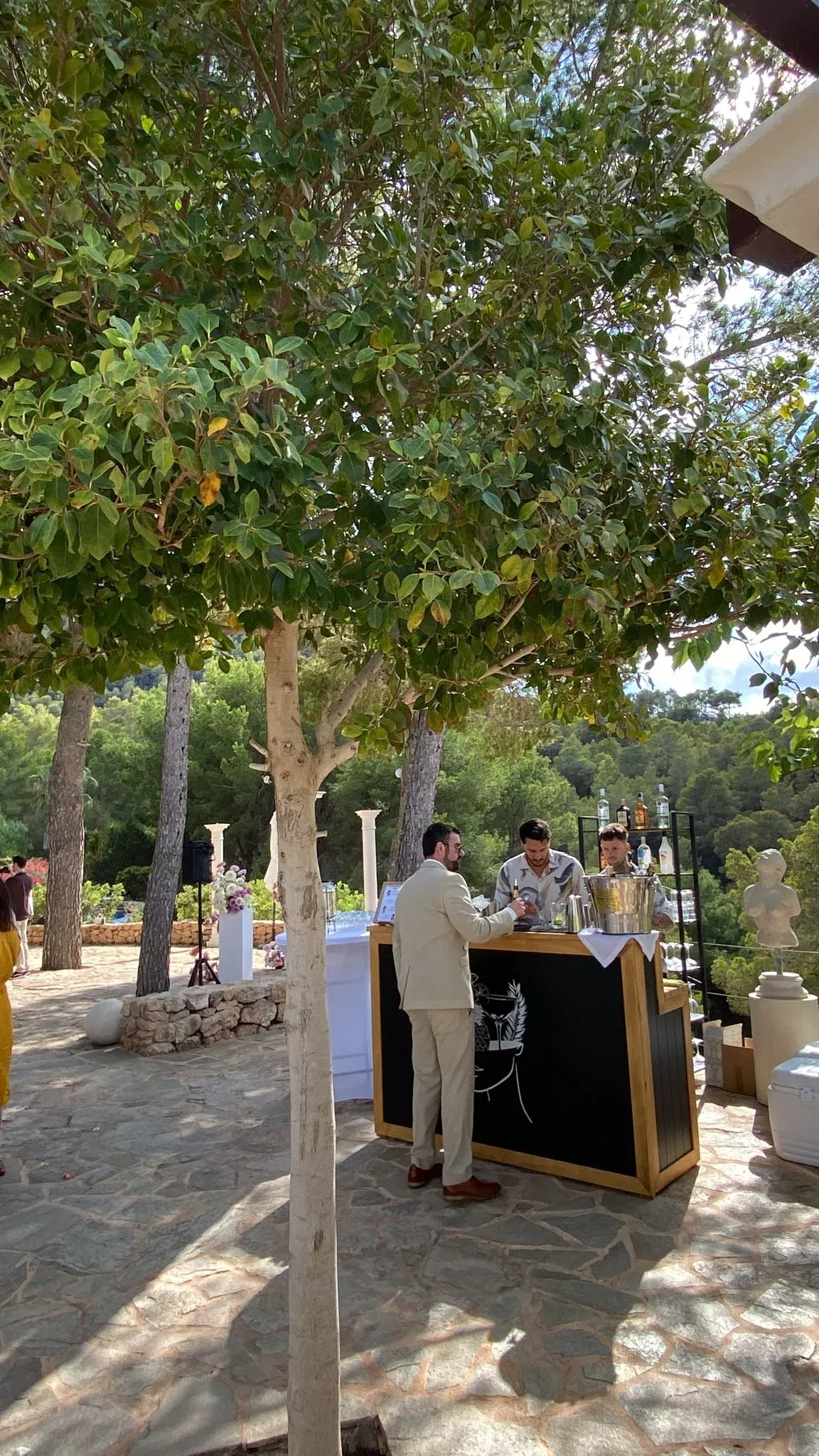 La barra móvil de Kibou montada bajo los árboles de una finca de Ibiza, atendiendo a un invitado