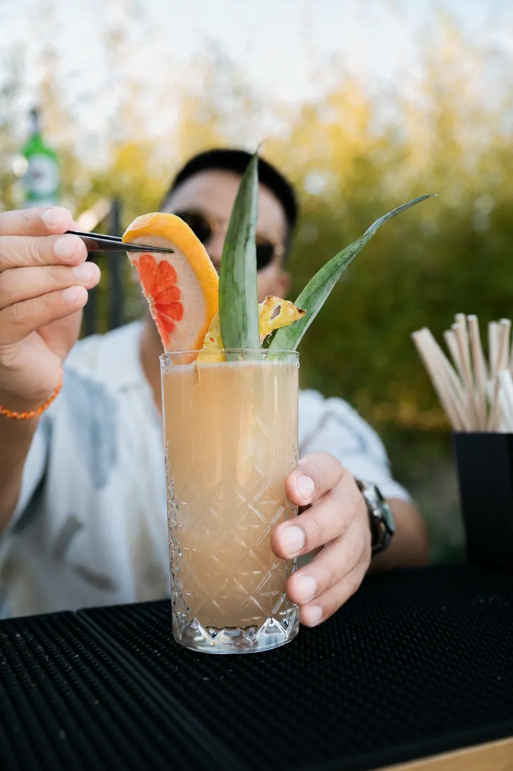 Kibou bartender finishing a cocktail with a fresh garnish